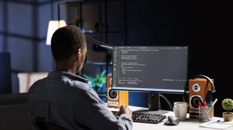 Male developer entering binary data on terminal panel while establishing html code. Software engineer works on troubleshooting with programming language, for protection of databases.